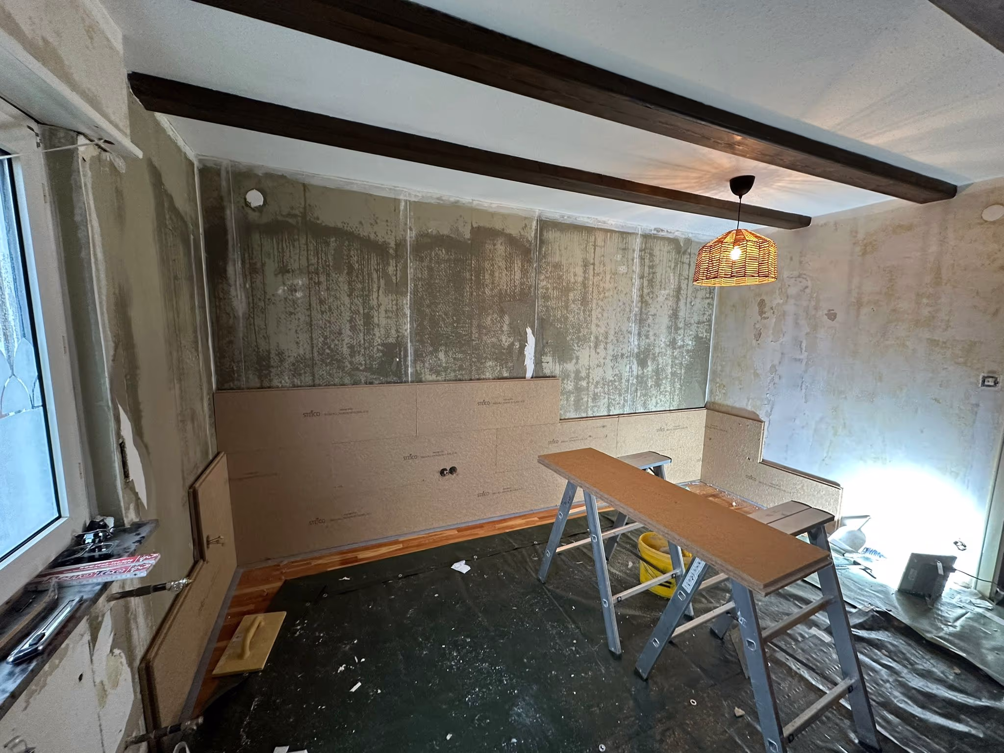 Handwerker bei der präzisen Anbringung einer hocheffizienten Innendämmung im Wohnbereich