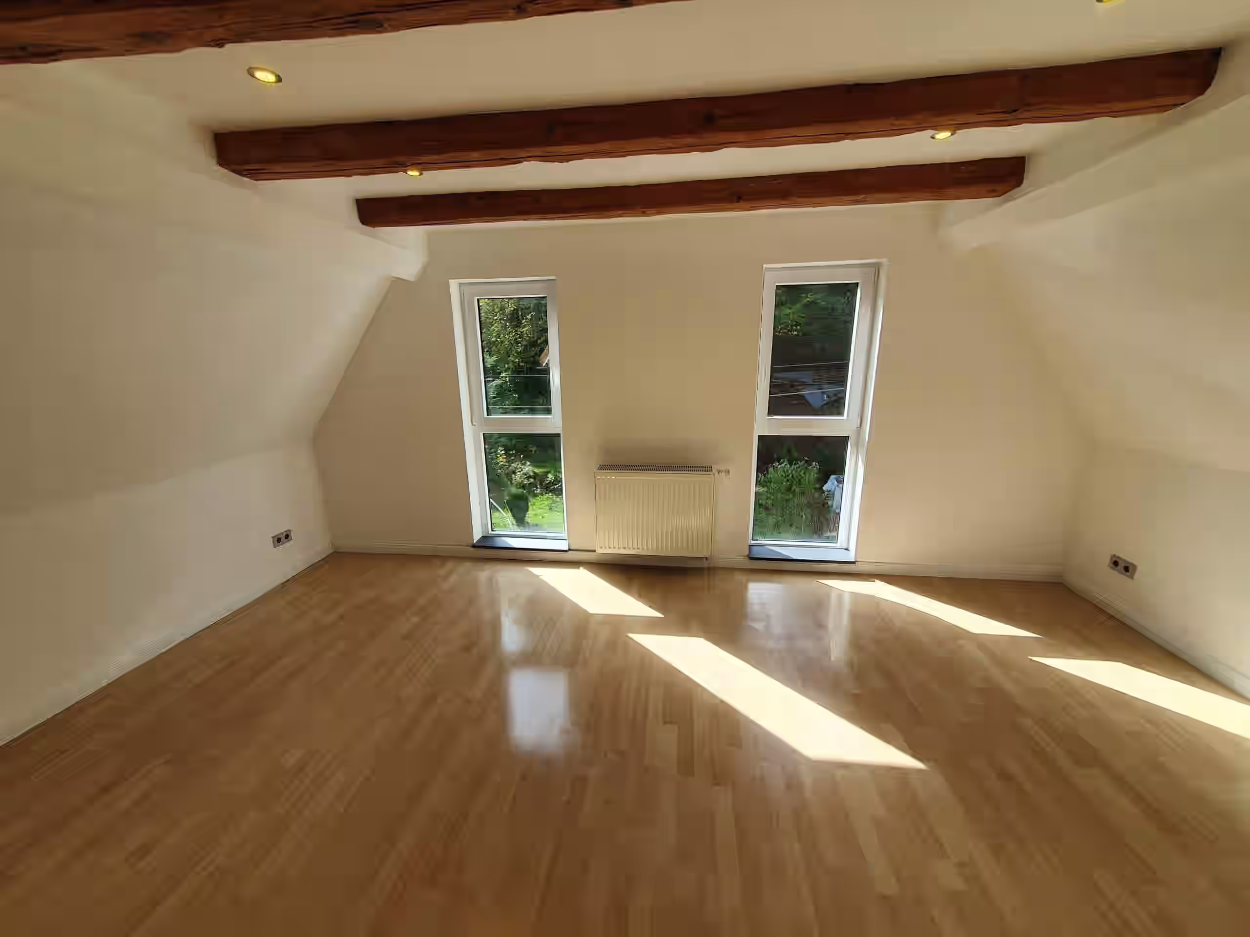 Modernisiertes Schlafzimmer mit neuem Lichtkonzept und Bodenbelag nach der Sanierung