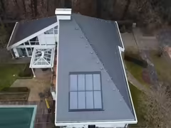Luftaufnahme eines Hausdachs mit Photovoltaikanlage