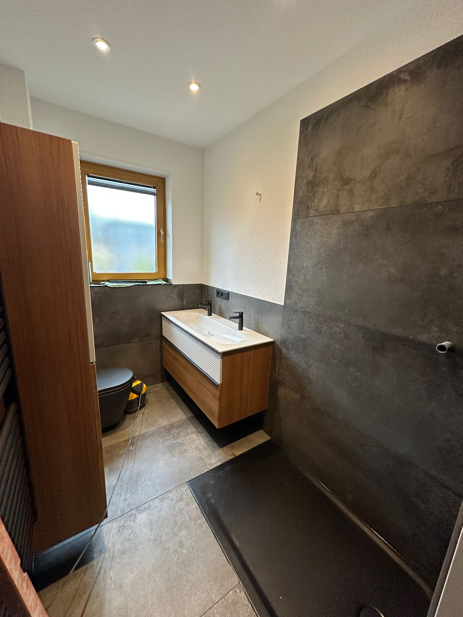 Elegante Badsanierung mit Waschtischunterschrank in Holzoptik