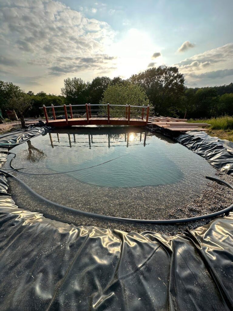 Großer Teich im Bau mit Teichbrücke im Hintergrund, Außenanlagen Rhein-Neckar